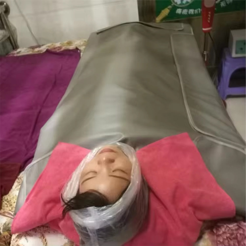 Person relaxing inside a far infrared sauna blanket during an at-home heat therapy session